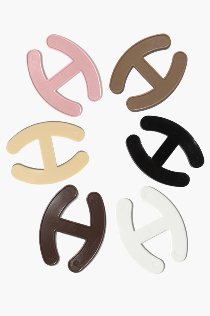 Set of multi-colored Strapper Bra Strap Adjusters in various shades for seamless bra strap concealment.